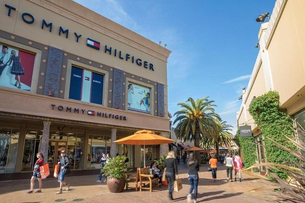 a group of people walking in front of a shopping mall