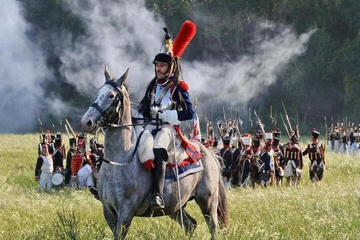Un hombre montado a caballo delante de un grupo de soldados.