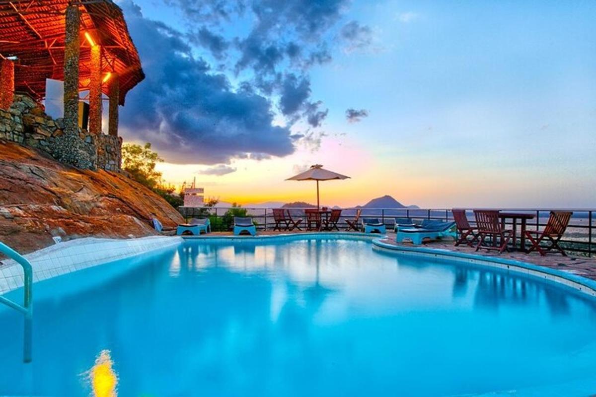 a swimming pool with a sunset in the background