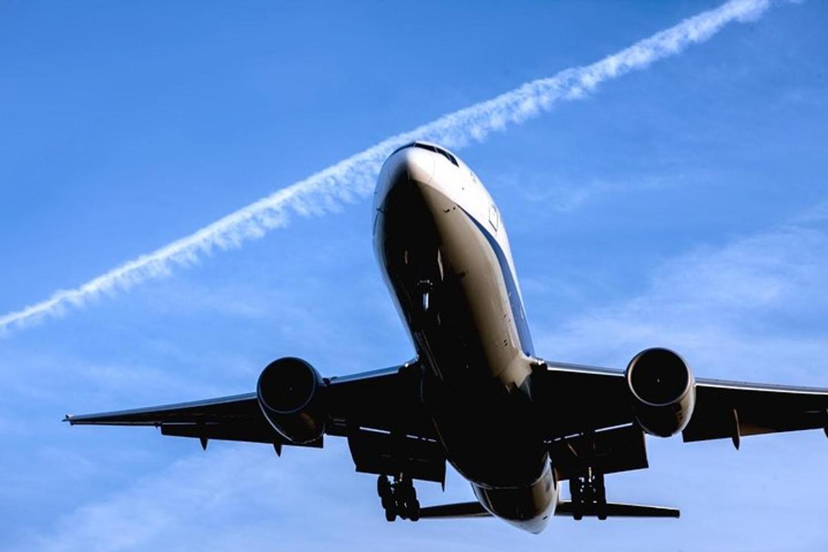 un aereo che vola nel cielo con una scia di fumo