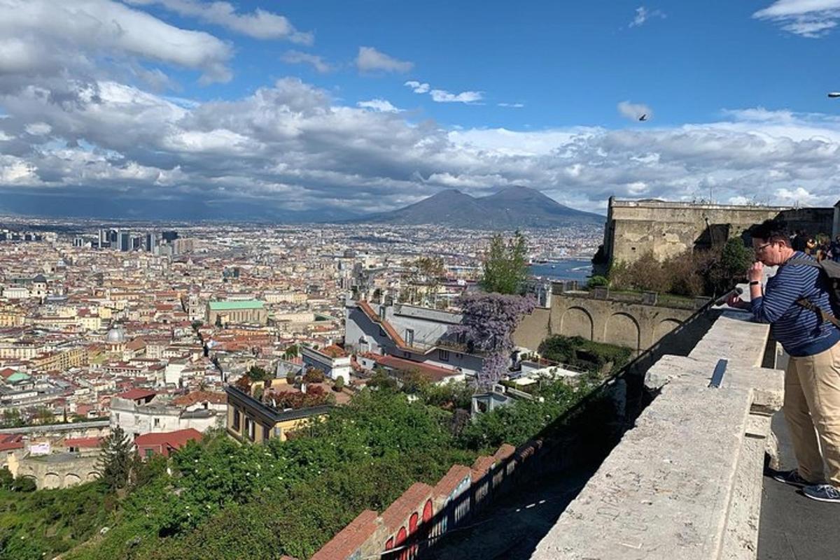 un bărbat care stă pe un zid și privește un oraș