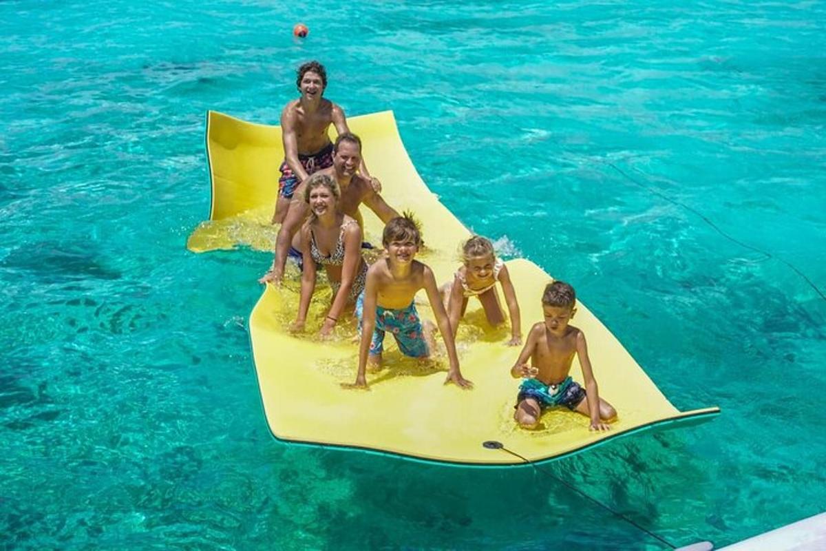 a group of children sitting on a paddle board in the water