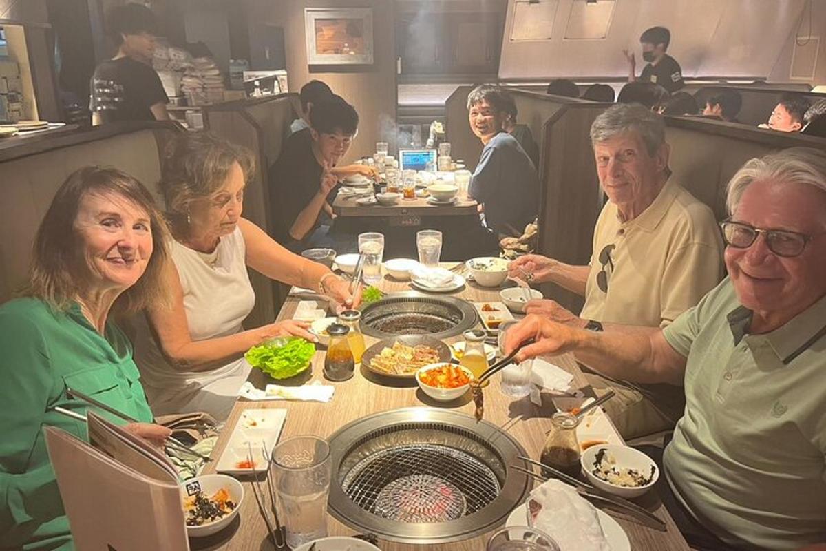 un gruppo di persone sedute a un tavolo che mangiano cibo