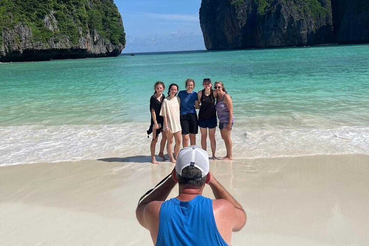 seorang lelaki mengambil gambar sekumpulan orang di pantai