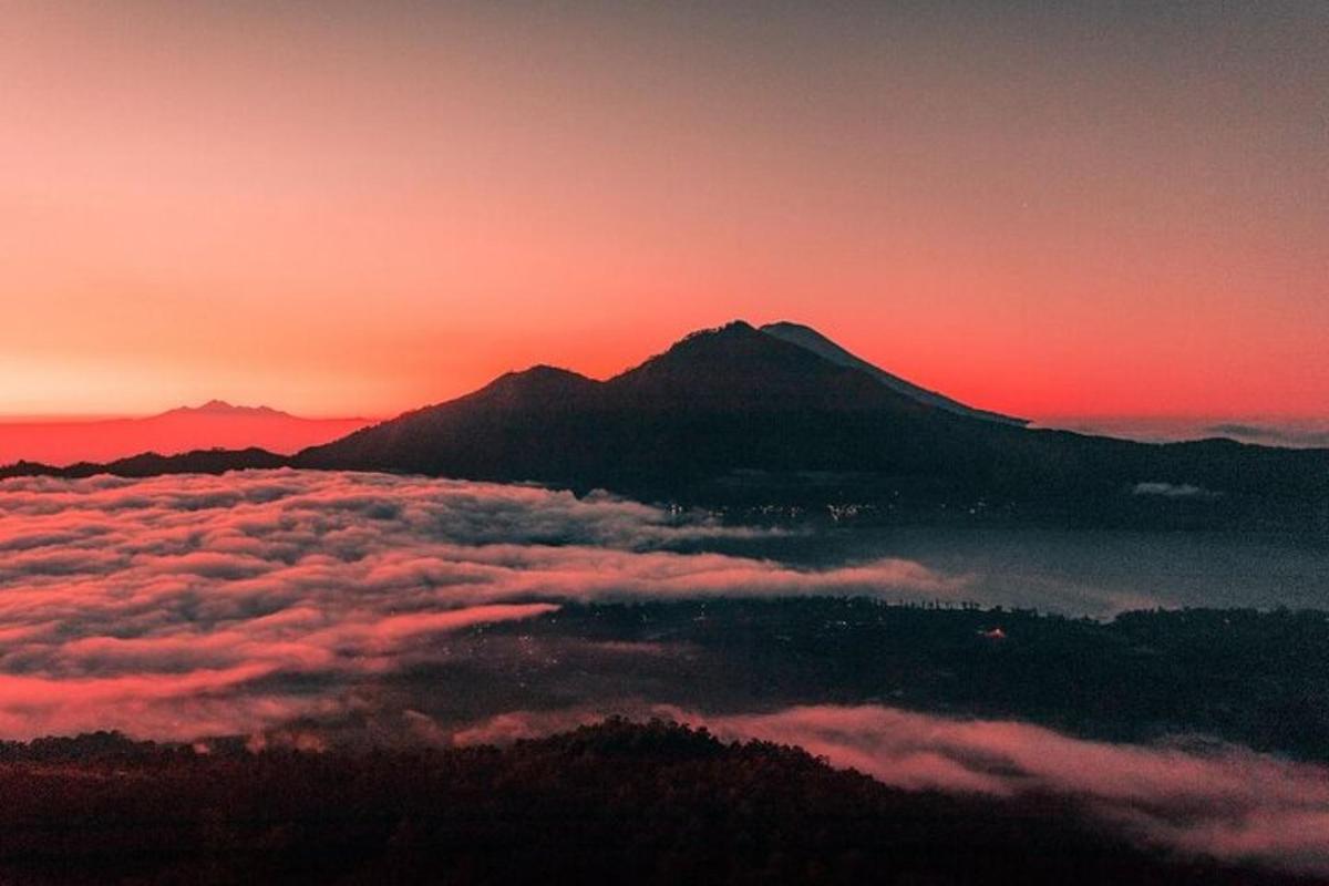 ein Berg über einer Wolkenschicht bei Sonnenuntergang