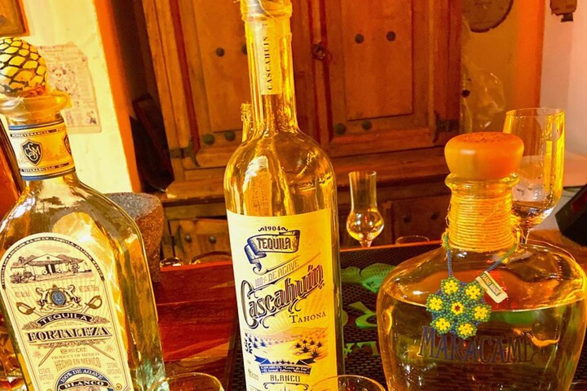 two bottles of alcohol on a table with glasses