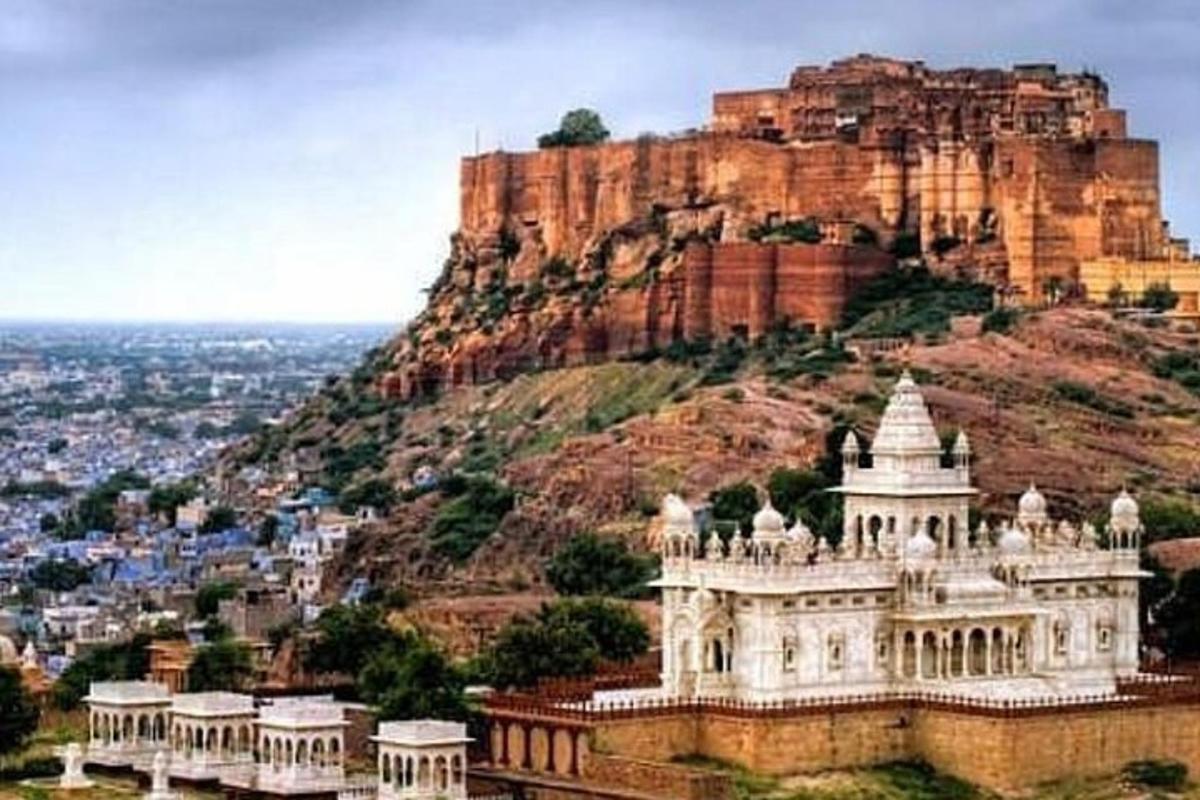 a building on a hill with a mountain in the background