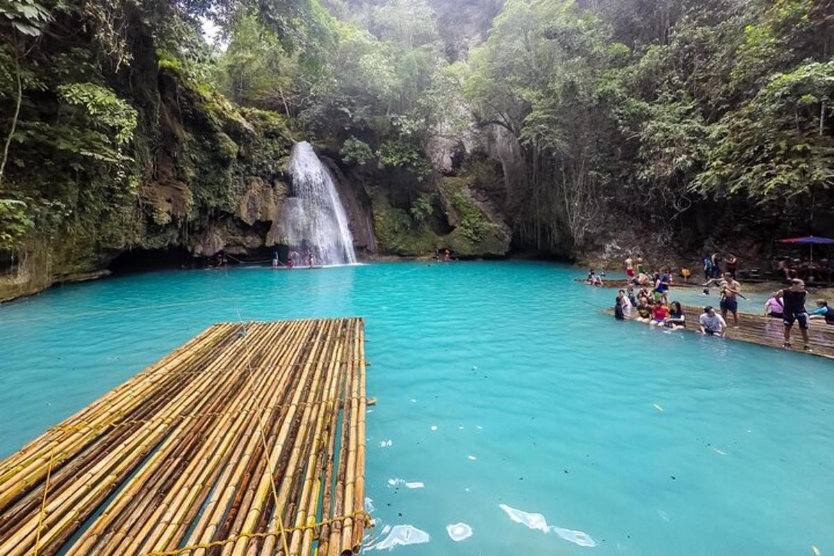 Un grupo de personas en una piscina de agua con una cascada.