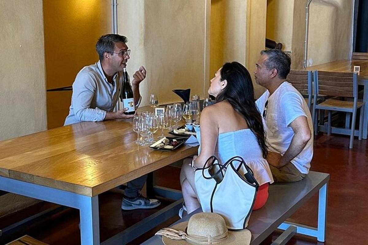 isang grupo ng mga tao na nakaupo sa isang mesa na may mga baso ng alak