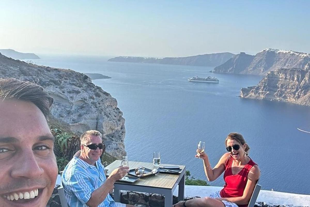 um grupo de pessoas sentadas à mesa com taças de vinho