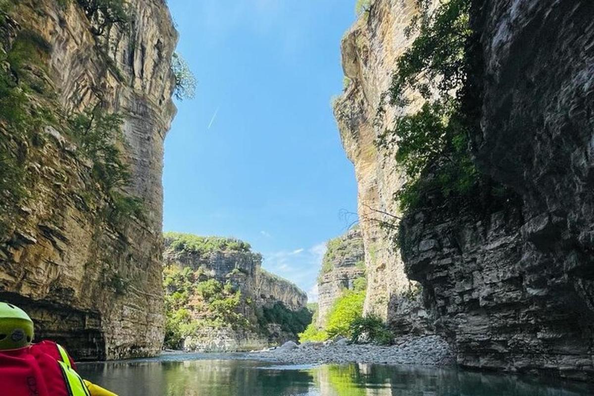 una persona su una barca in un fiume tra due scogliere