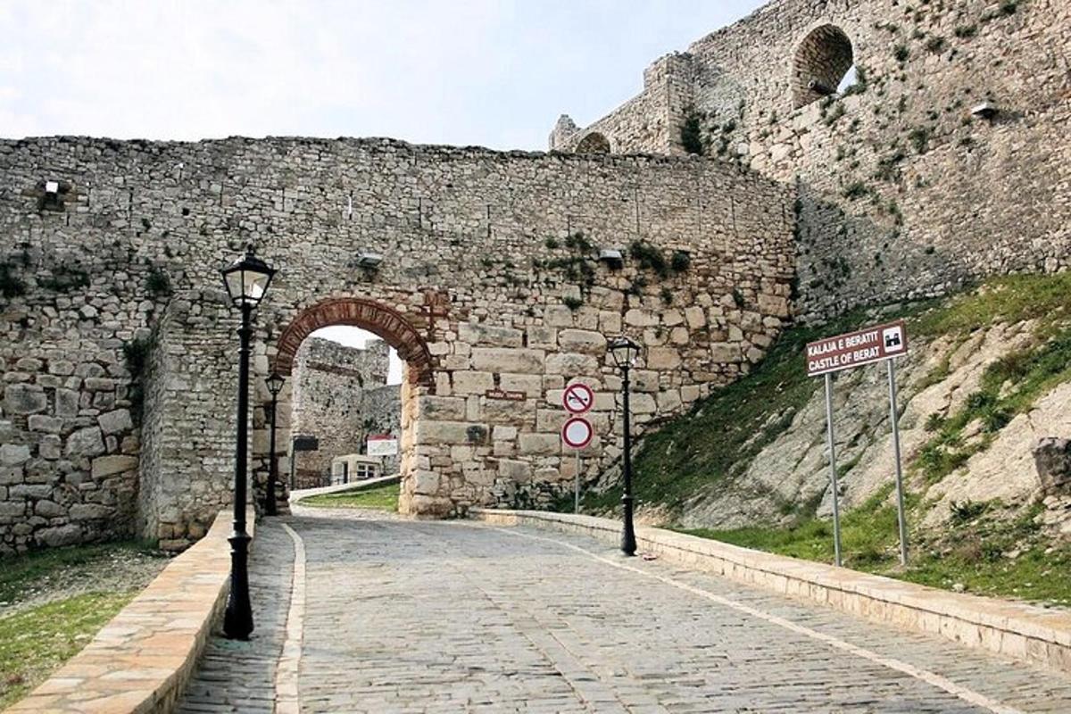 un arco in un muro di pietra con una strada