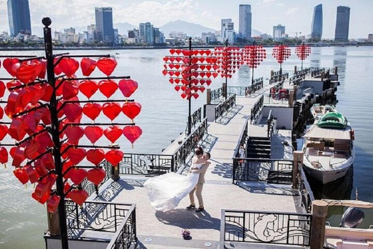 Un hombre y una mujer de pie en un muelle con corazones.