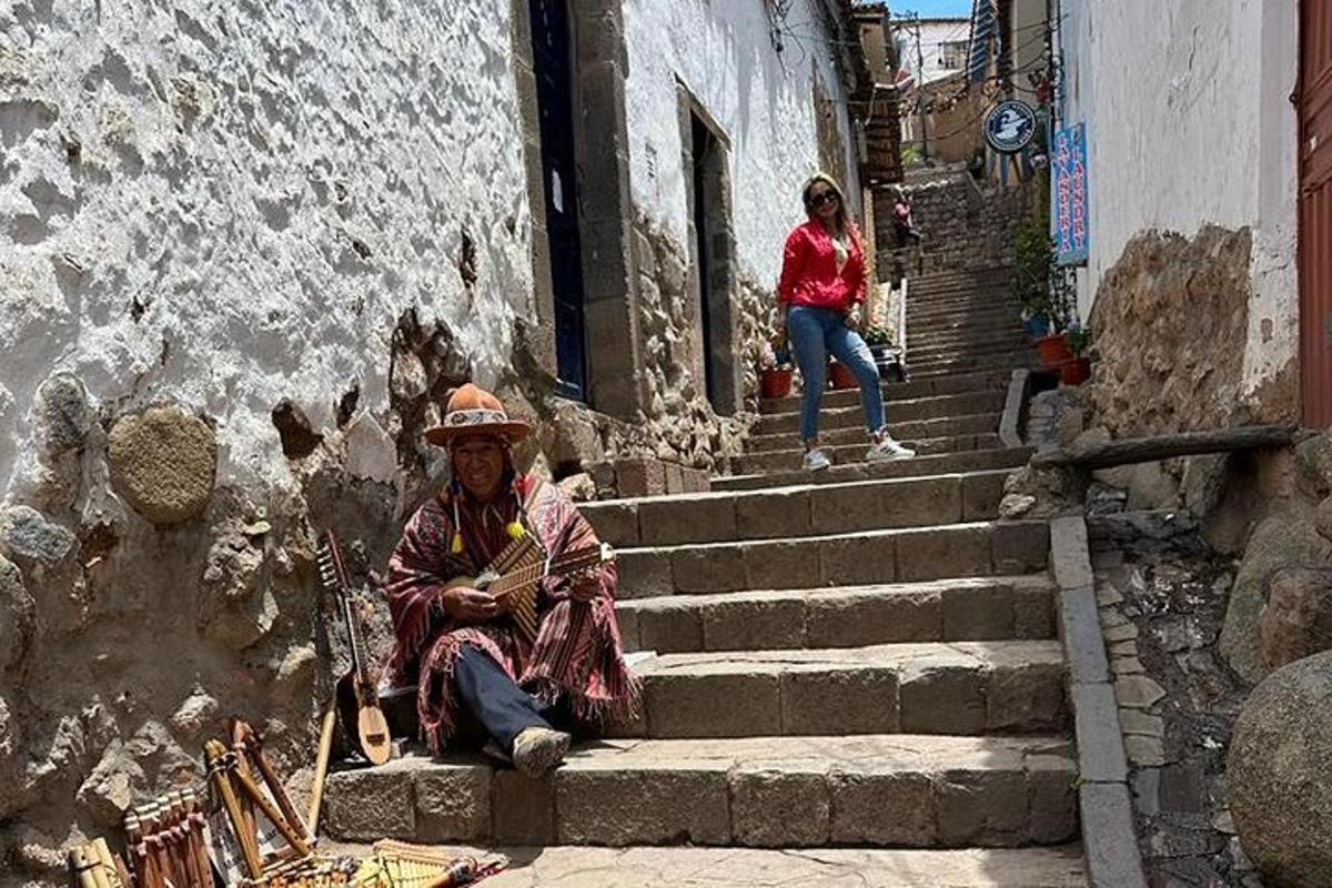Un hombre sentado en unas escaleras de un callejón.