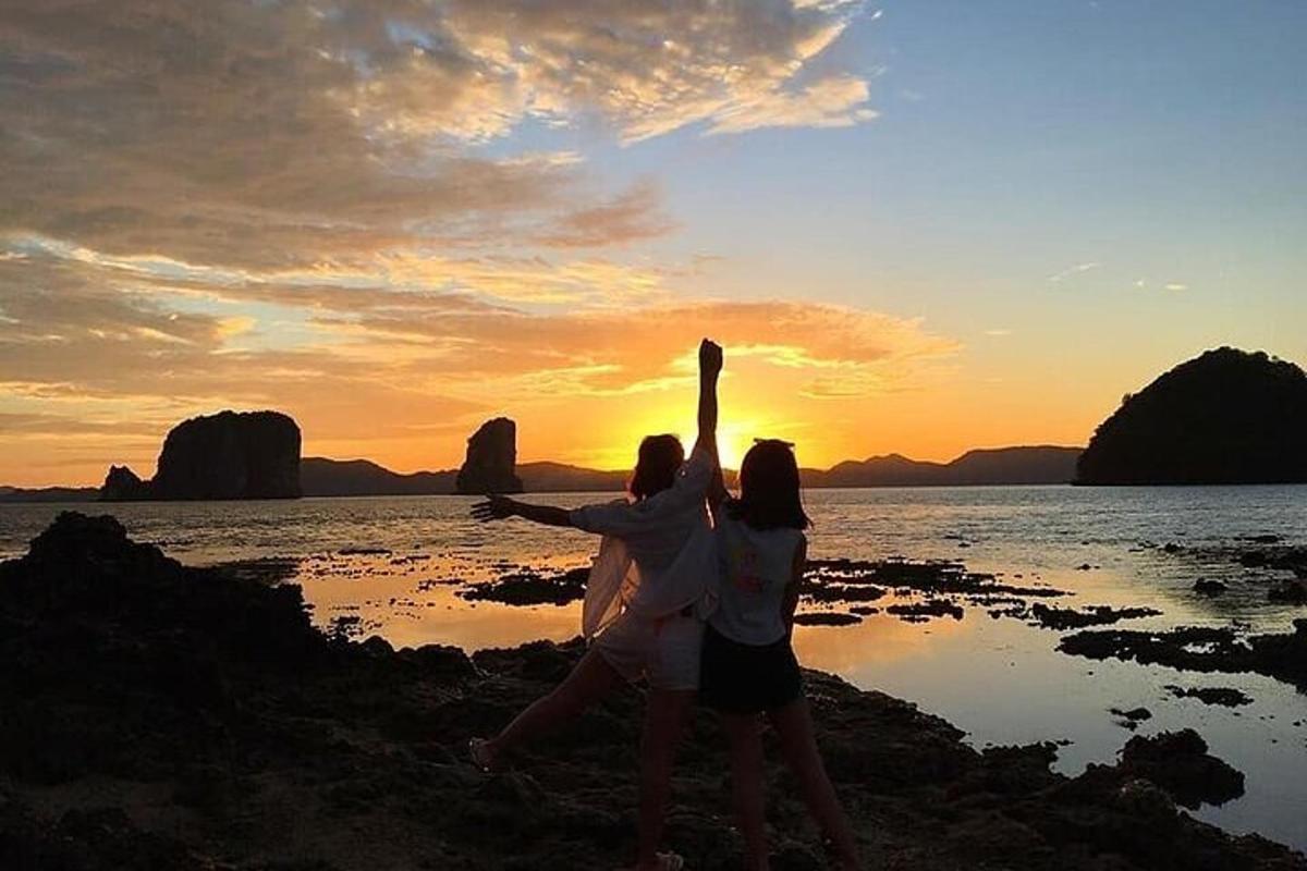 due donne in piedi sulla spiaggia al tramonto