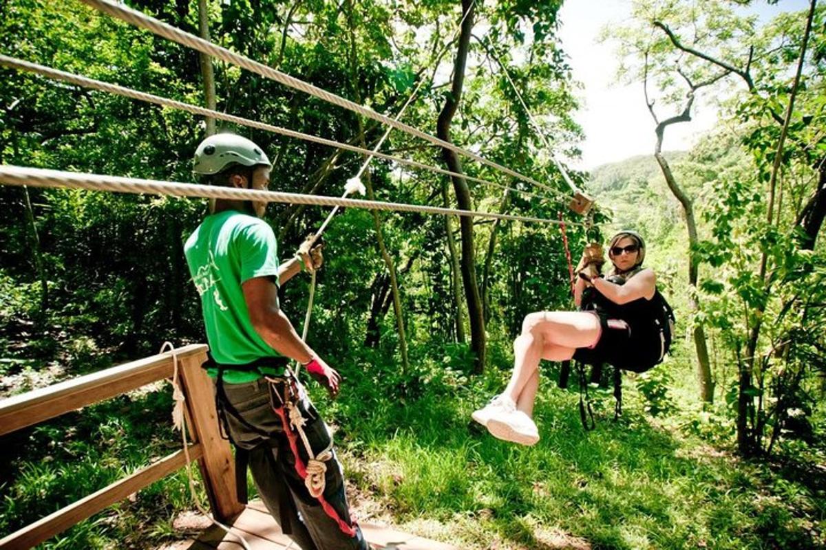 a man and a woman on a zip line in the woods