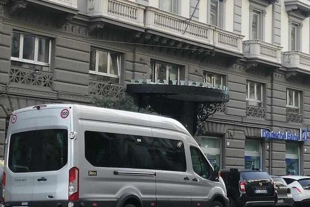 biały van zaparkowany przed budynkiem
