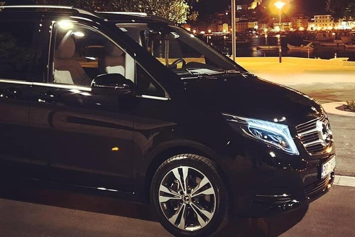 ein schwarzes Auto, das nachts auf einem Parkplatz geparkt ist