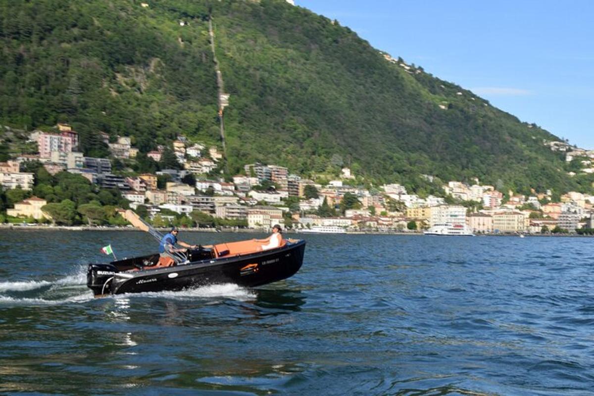 two people in a boat on a lake with a mountain