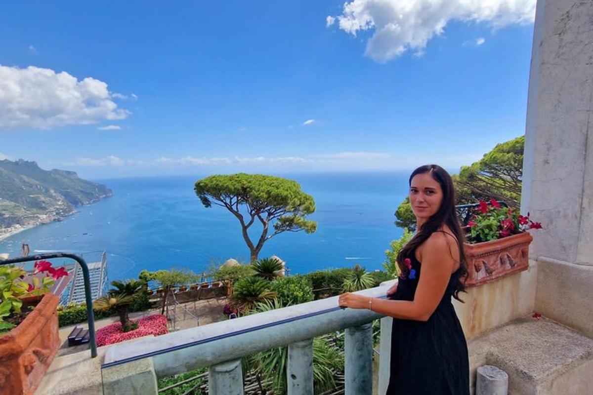 una donna in piedi su un balcone con vista sull'oceano