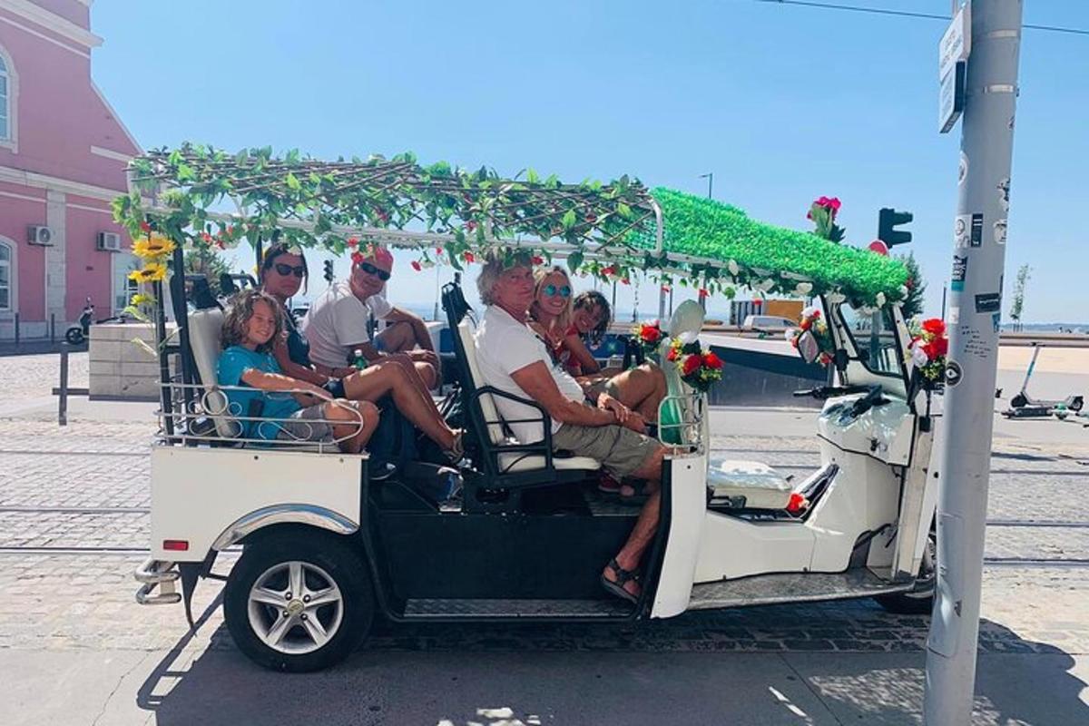 skupina lidí jedoucích v golfovém vozíku