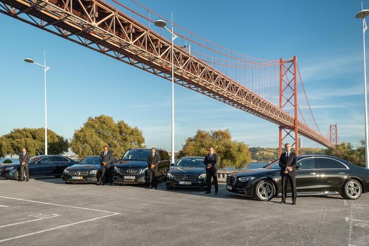 skupina mužů stojících před auty pod mostem