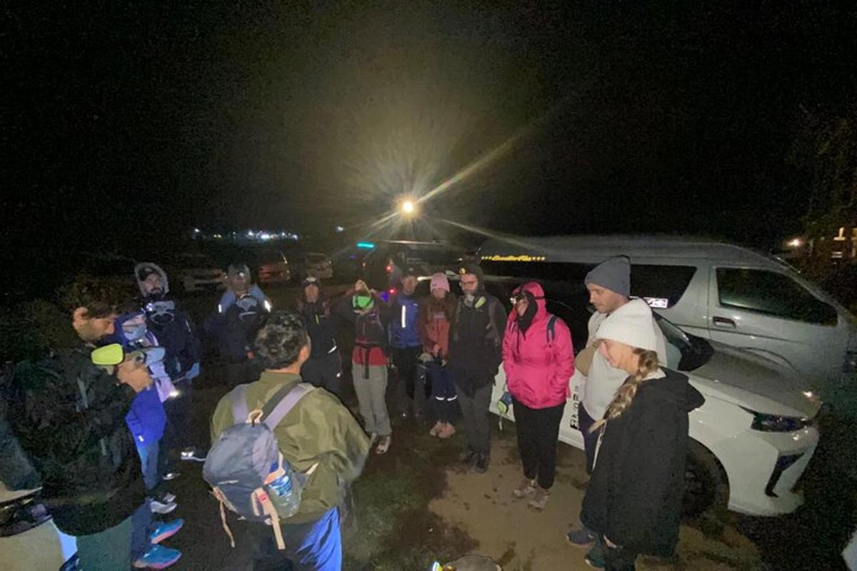 a group of people standing around a van at night