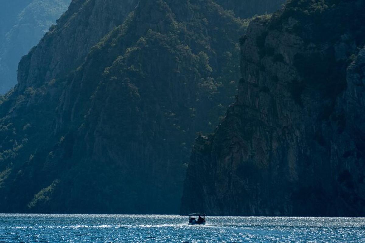 un barco en el agua al lado de una montaña