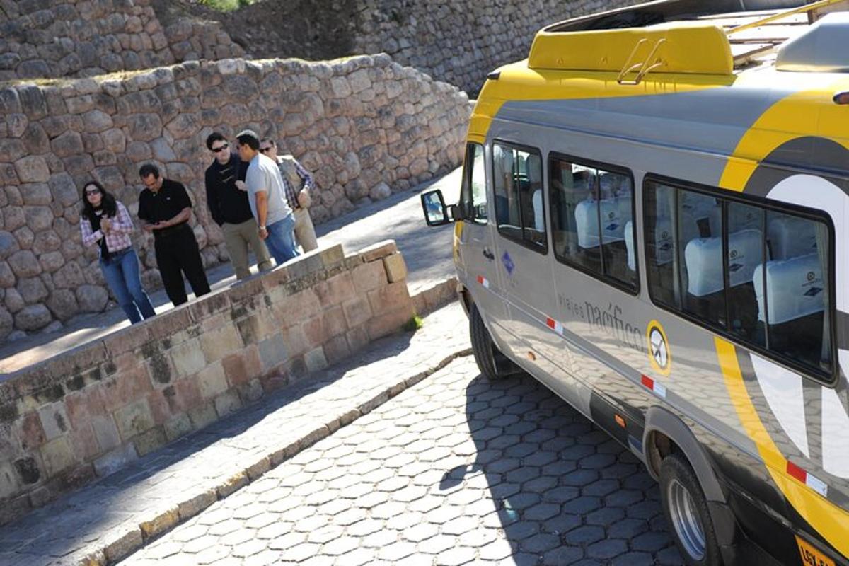 skupina lidí stojících na zdi vedle autobusu