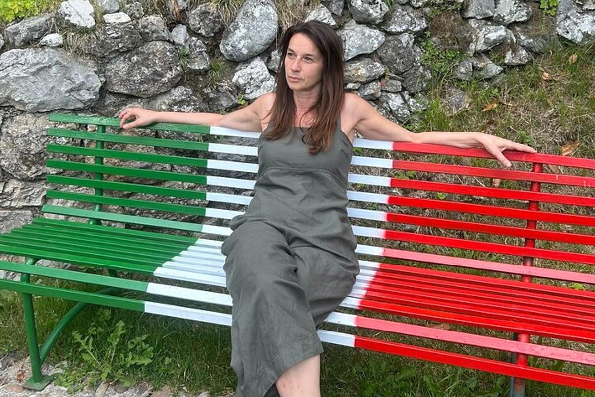 μια γυναίκα με φόρεμα που κάθεται σε ένα παγκάκι