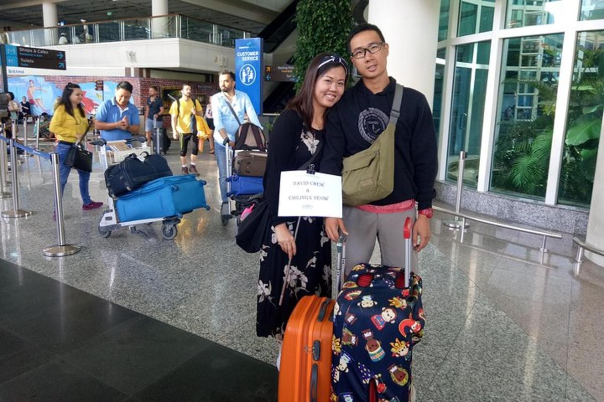 un uomo e una donna posano con i loro bagagli in un aeroporto
