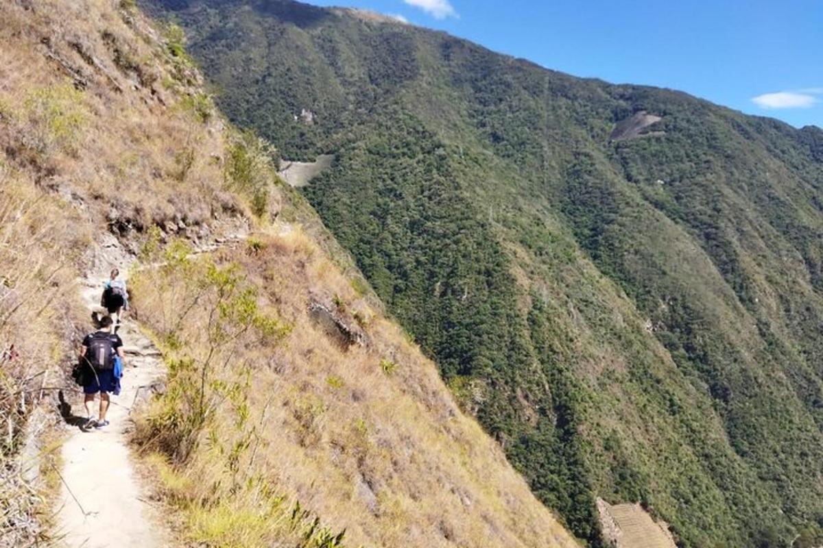 dos personas caminando por un sendero en una montaña