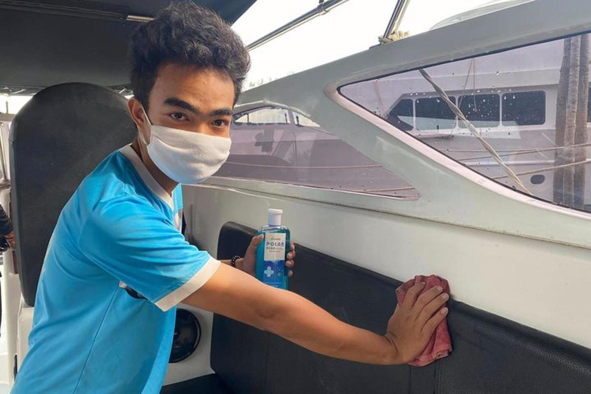 seorang lelaki bertopeng memegang sebotol pembersih di atas bot