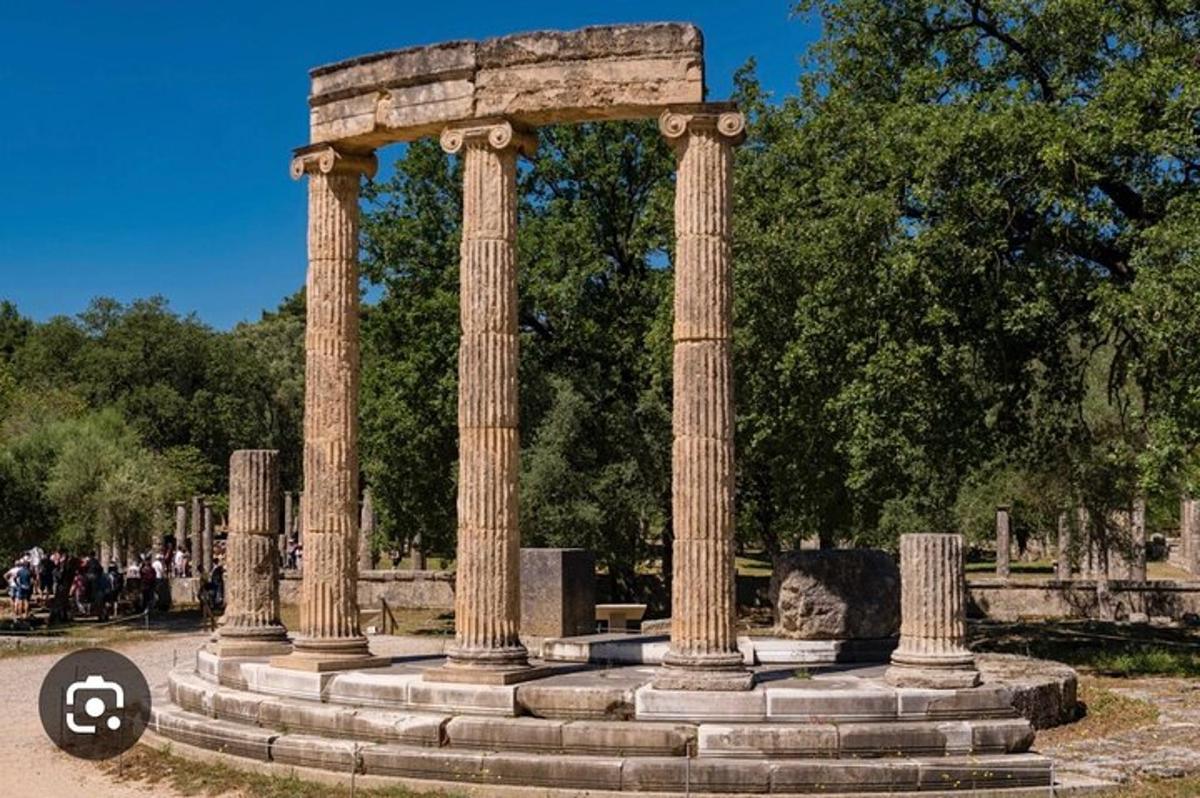 un monumento con colonne in un parco con un cartello
