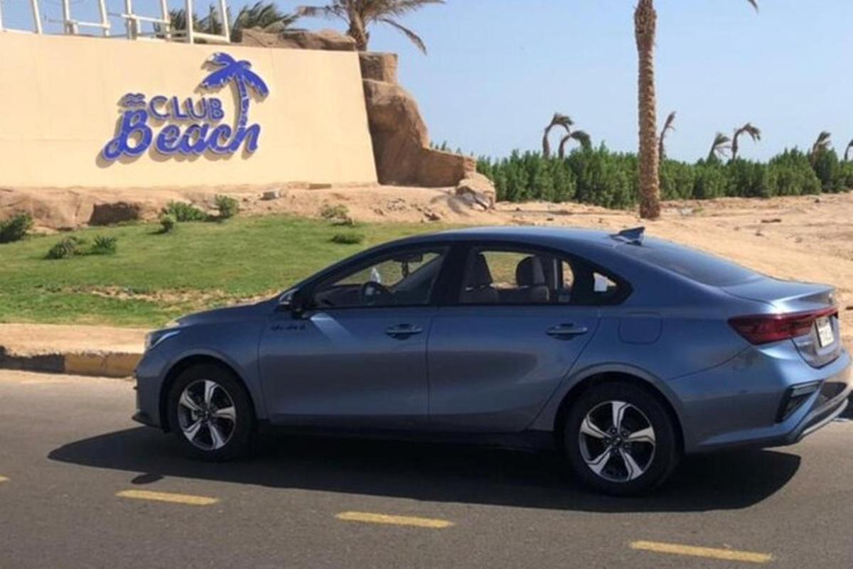 egy kék autó parkolt a strand előtt