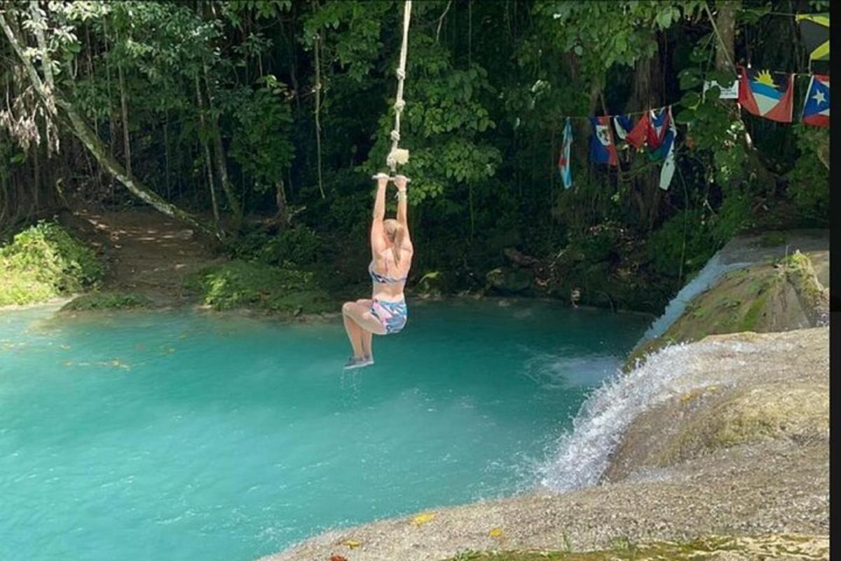 a woman hanging from a rope in a body of water