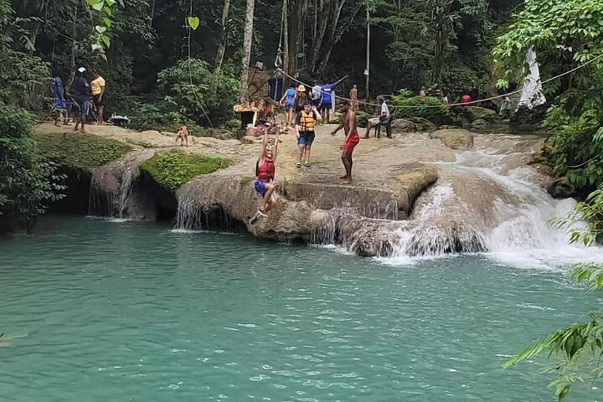 sekumpulan orang melompat ke dalam air terjun di sungai