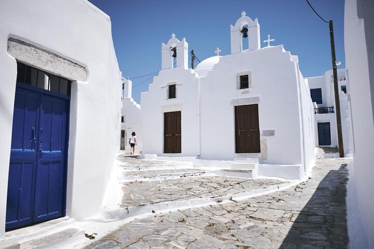 Un edificio blanco con una puerta azul y dos iglesias.