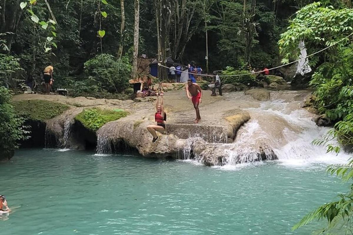 a group of people standing in a waterfall in a river