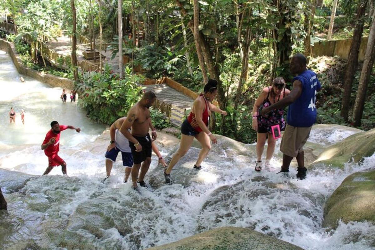 sekumpulan orang bermain air di air terjun