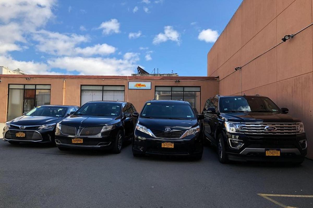 un gruppo di quattro auto parcheggiate davanti a un edificio