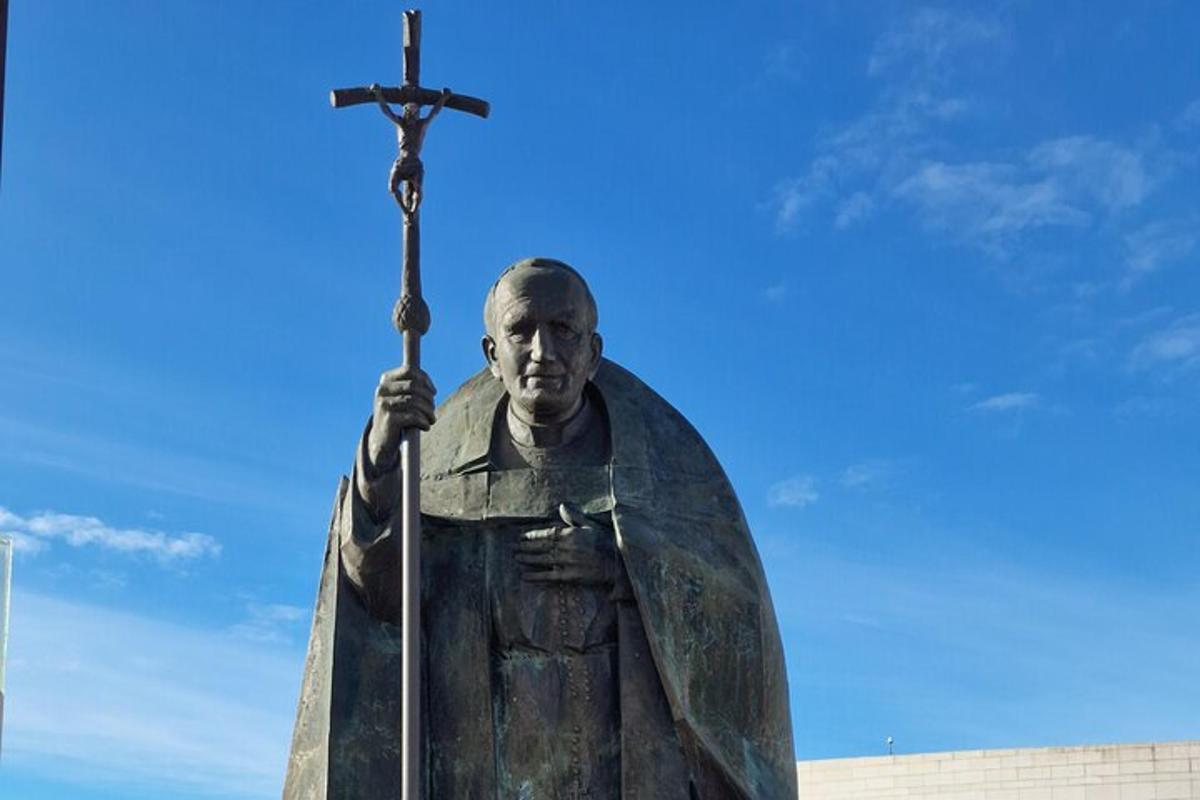 uma estátua de um homem segurando uma espada e uma cruz