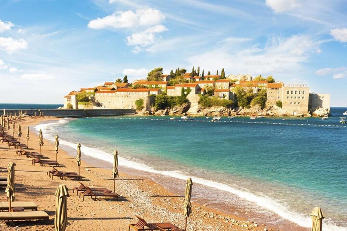 a beach with chairs and buildings and the ocean