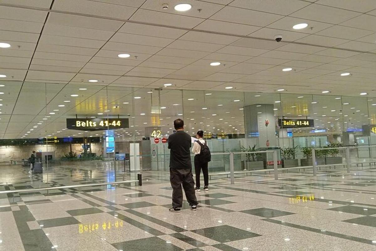 dua orang berdiri di terminal lapangan terbang yang besar
