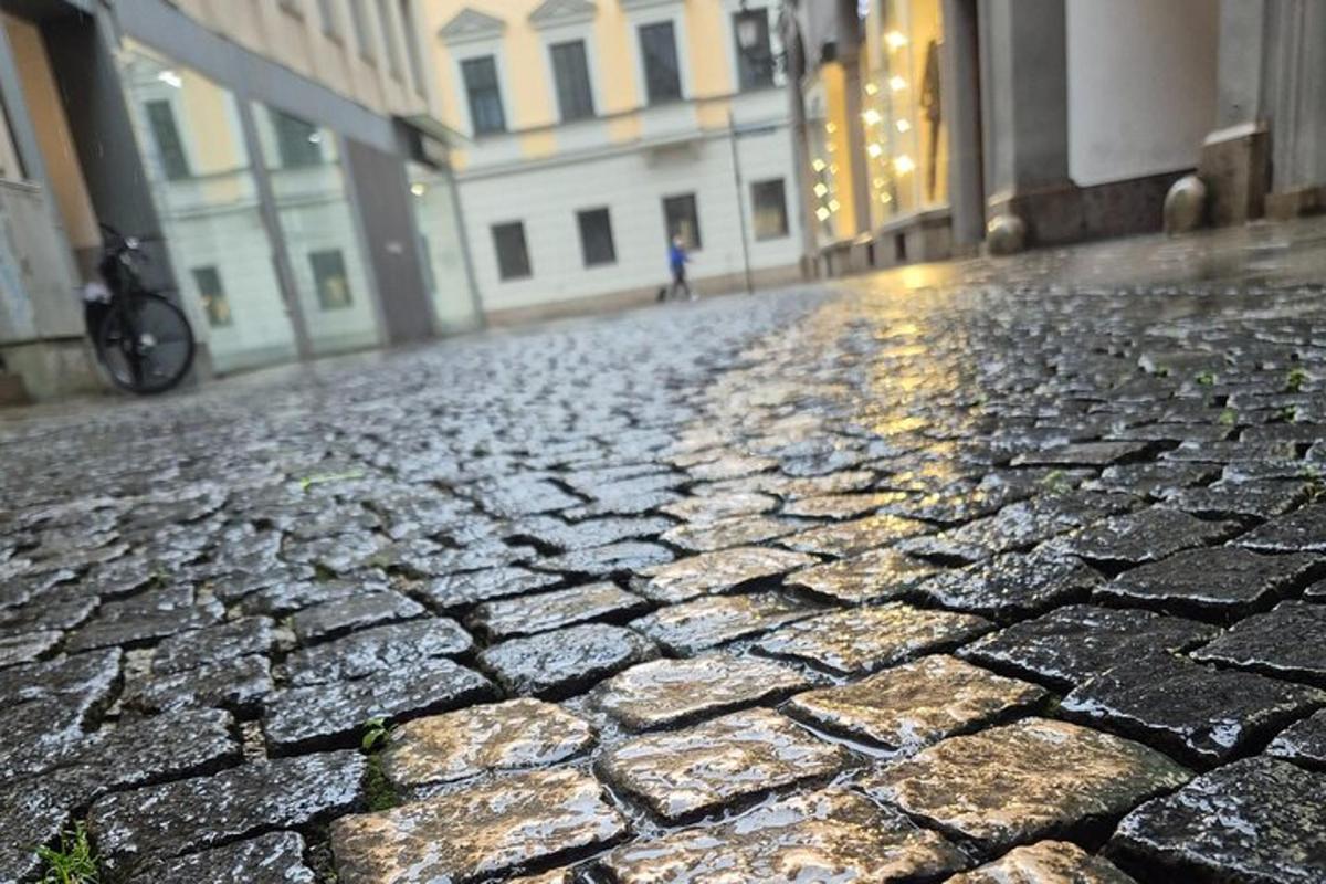 tlakovana ulica z osebo, ki hodi po ulici