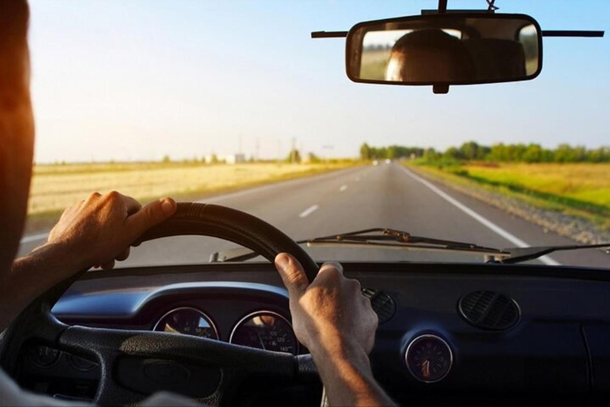 un bărbat conducând o mașină pe un drum