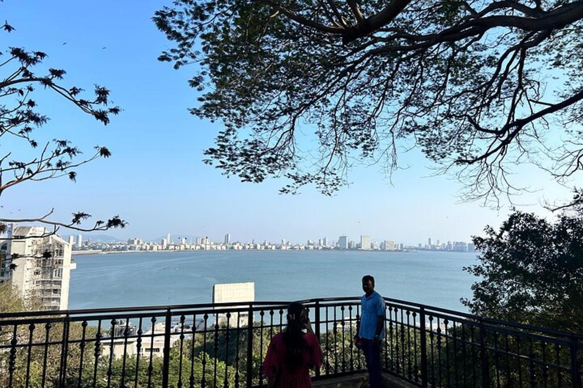 a man and woman standing next to a fence overlooking the water