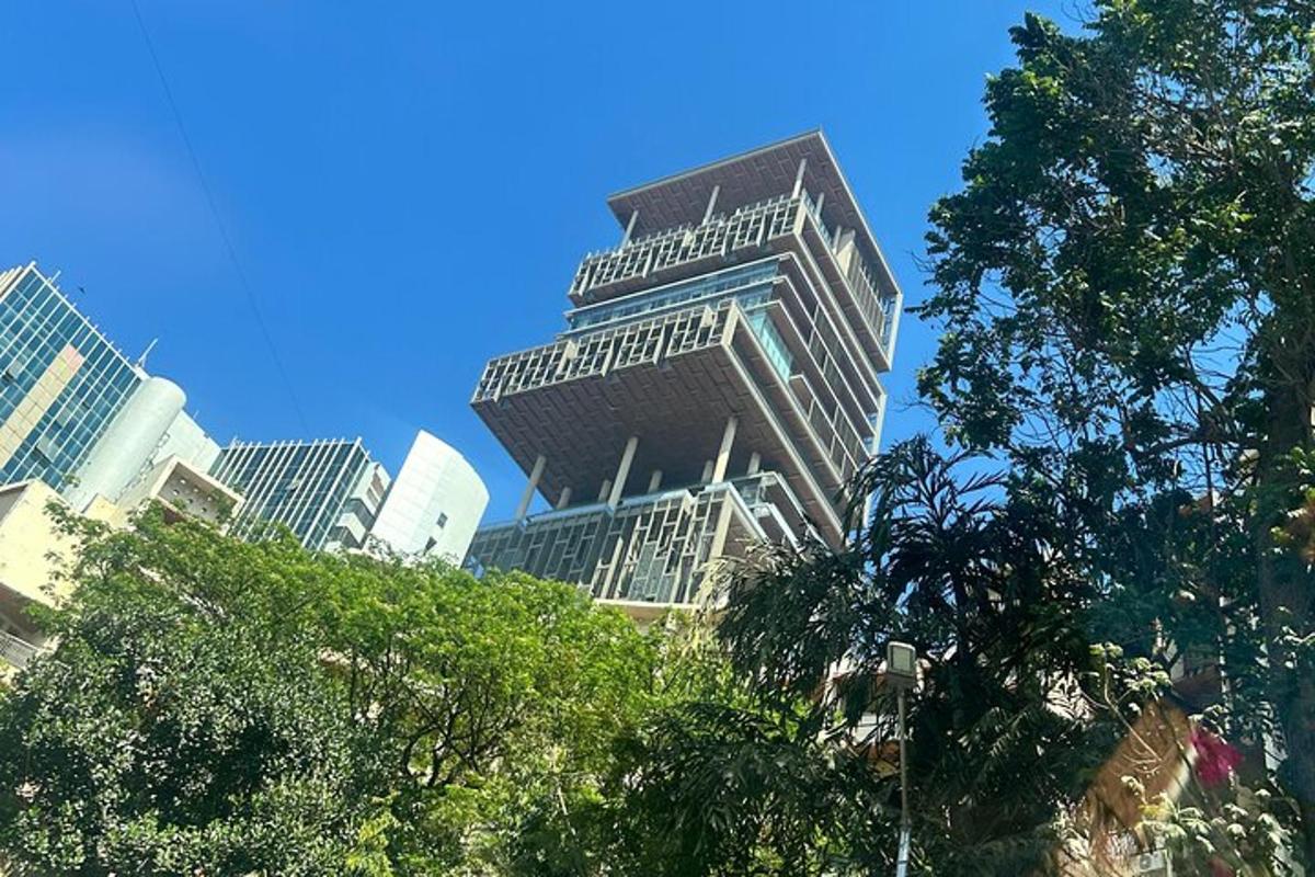 a tall building in a city with trees in the foreground