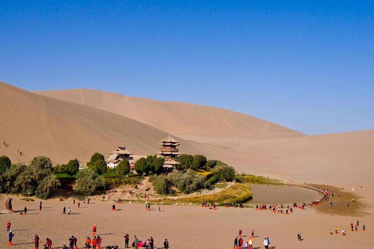 a group of people standing in a desert with a building