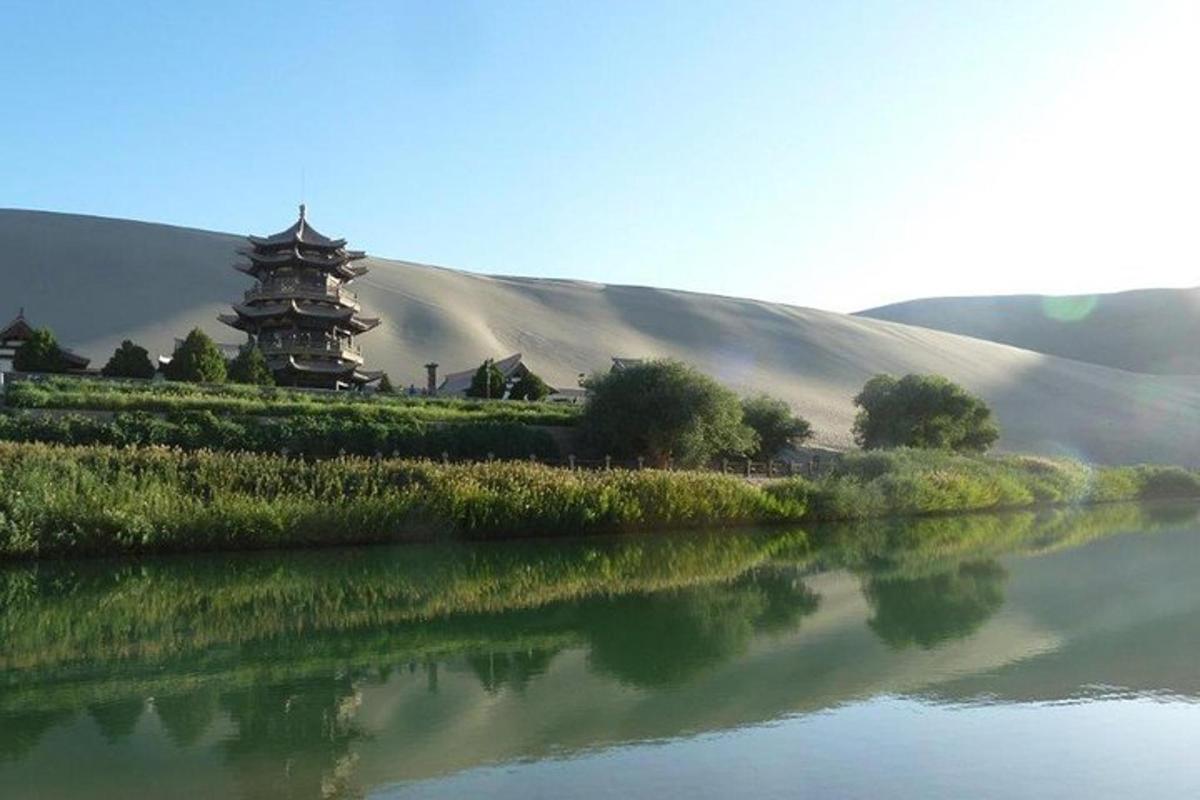 a building on a hill next to a body of water
